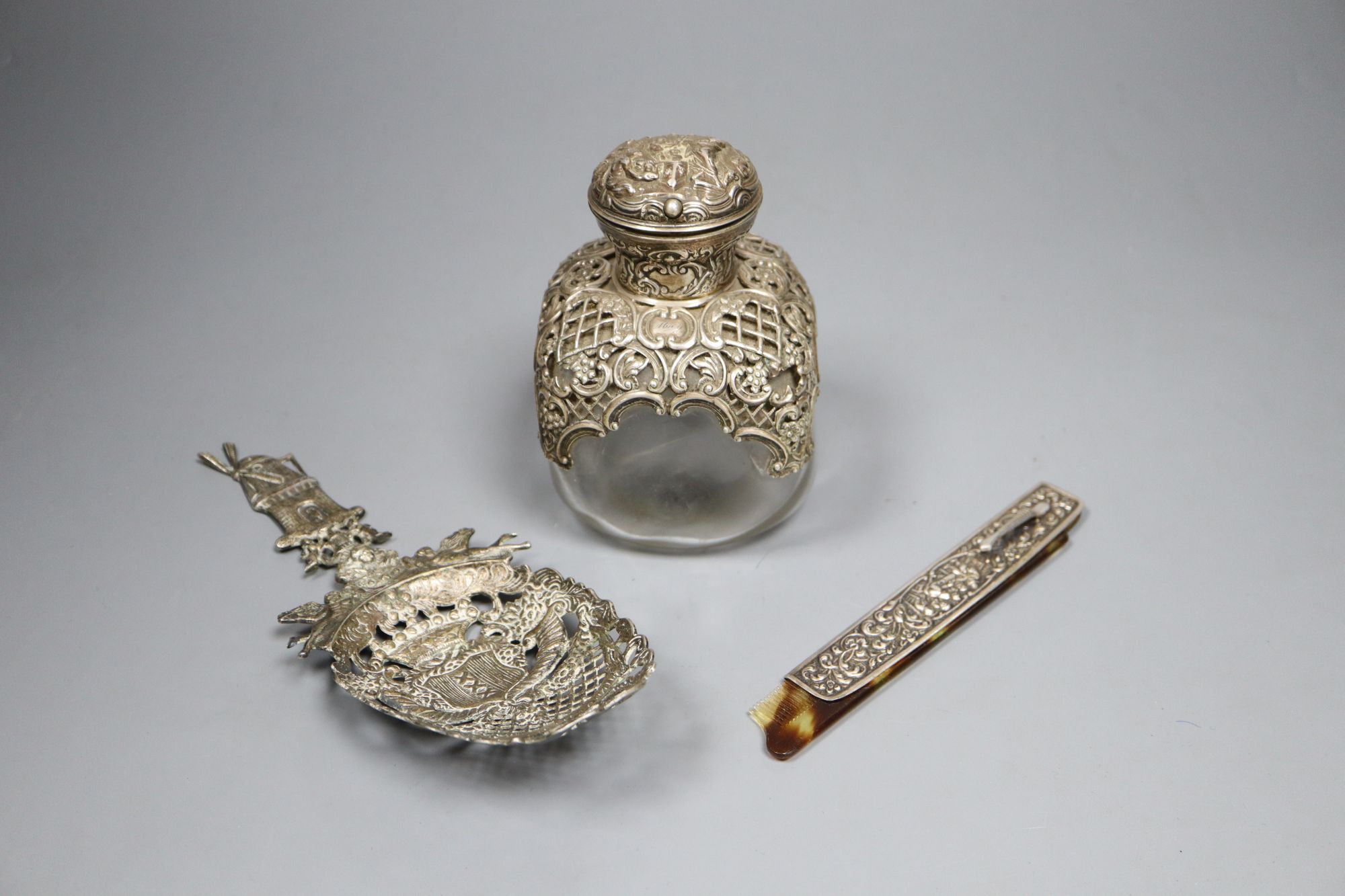 A Victorian silver mounted glass scent bottle, maker Wm. Comyns, 1894, height 12cm, a Dutch white metal novelty spoon and a folding com